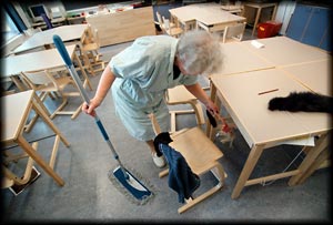 Hilda Korhonen siivoamassa pienten pulpettien alta. Foto: PATRIK LINDSTRÖM