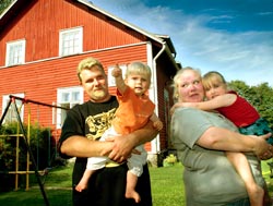 Tomi Vastam�ki ja Sanna Marjam�ki sek� lapset Kasper ja Julie nauttivat kes�p�ivist� vanhan puutalon pihamaalla. Foto: JUHA SINISALO