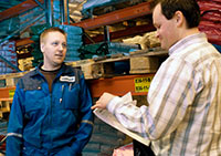 Sami Keskinen kertoo Oskar Aholle, ett� varaston ty�ntekij�ist� on ruuhka-aikoina jopa puolet vuokraty�ntekij�it�. Foto: HELI SAARELA