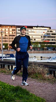 Puuliiton puheenjohtaja Sakari Lepola viihtyy j�senporukoissa, mutta my�s yksin lenkill� tai ladulla. Jos ay-toiminta on joukkueurheilua, niin Lepolan tavat rentoutua ovat pikemminkin yksil�lajeja. Aurinko oli juuri noussut, kun Lepola juoksi Kruununhaan rantaa. Taustalla n�kyv�ss� Merihaan liittojen talossa on my�s Puuliiton toimisto. Foto: TUULIKKI HOLOPAINEN